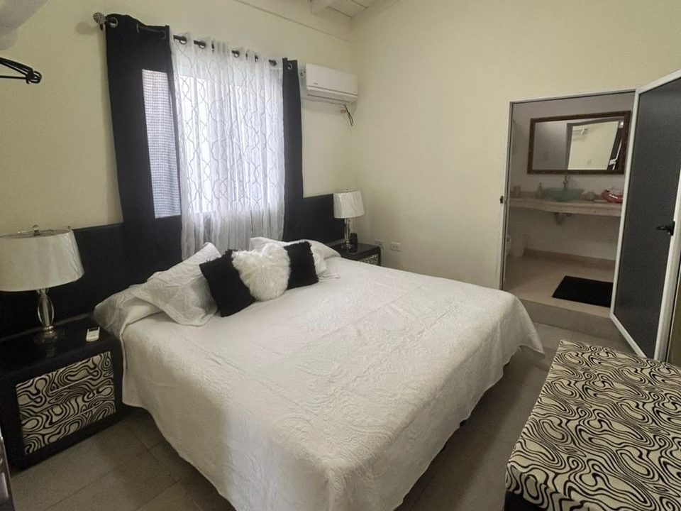 Habitación con cama queen y baño